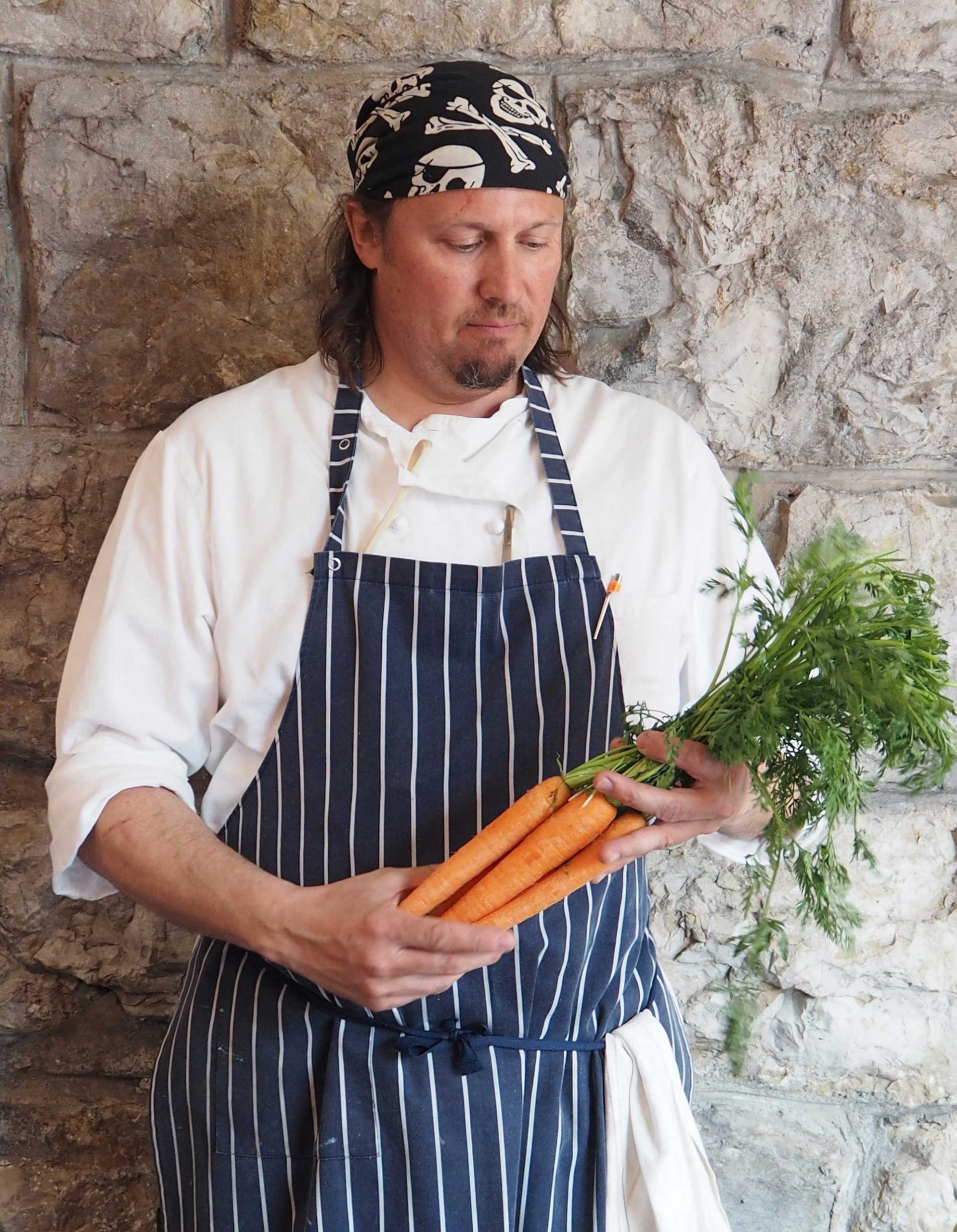 Mischa Kaeser (Küchenchef Restaurant Italia in Zürich) hält ein Bund Karottenkraut in den Händen.
